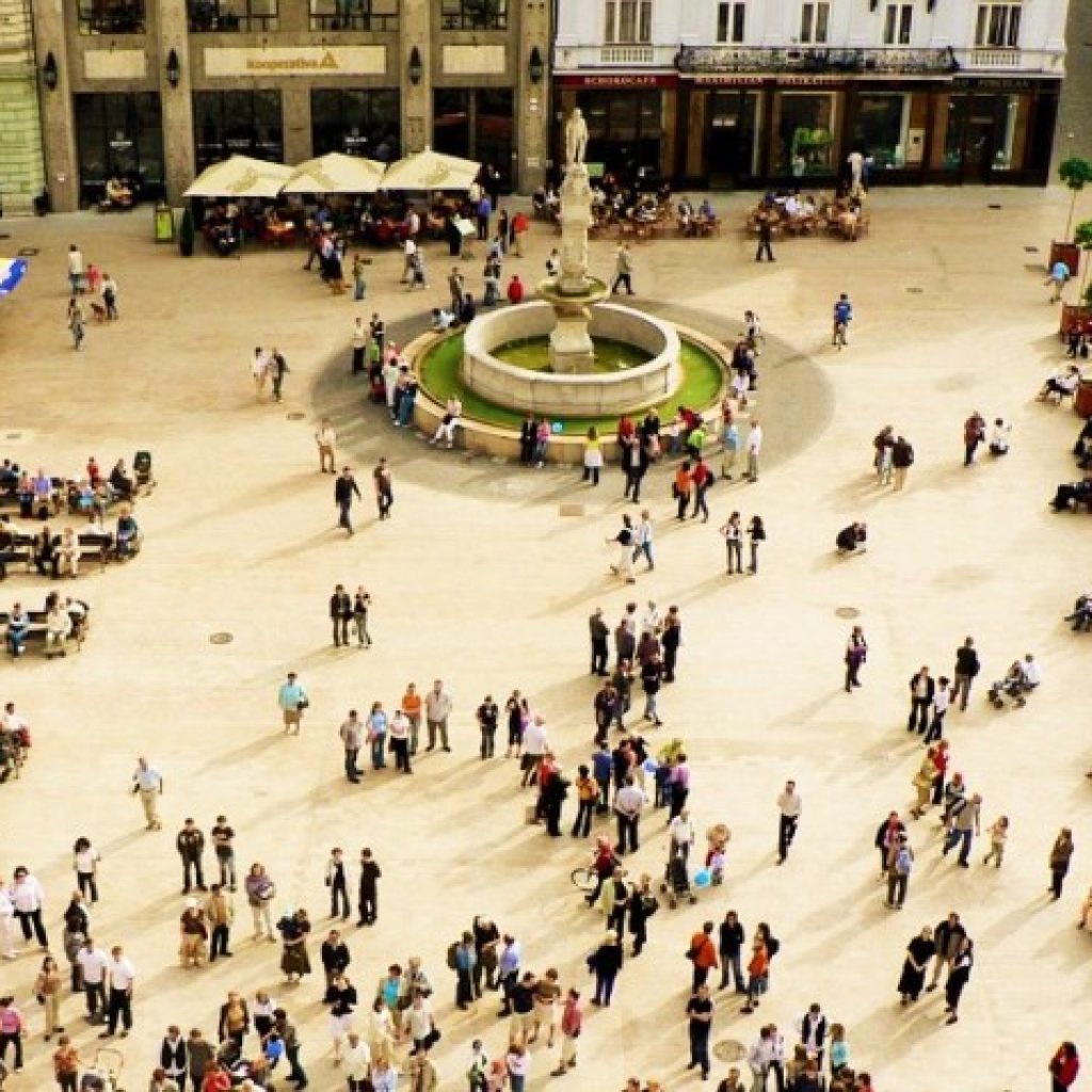 a town square filled with people shot from a birds eye view