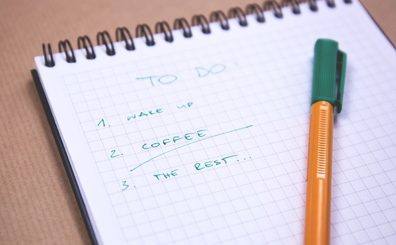 A written to do list on a notepad with a pen placed on top