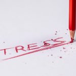 The words stress written with a read pencil breaking on impact