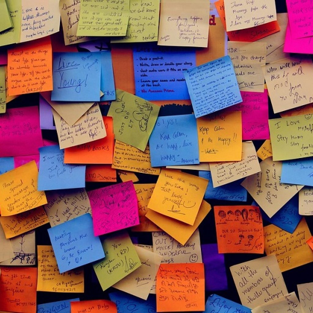 A wall covered in multicoloured post it notes with tips and positive messages