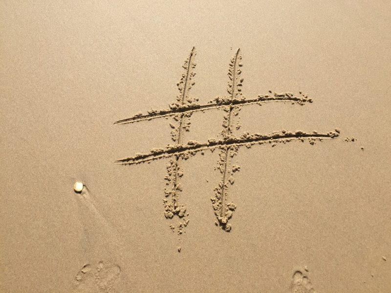 Hashtag symbol curved out in some wet sand