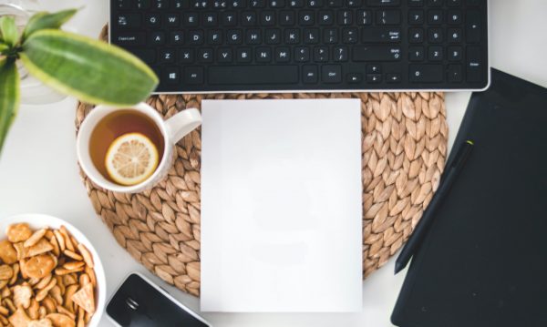 Working space with a keyboard, tea cup, plant and snack bowl