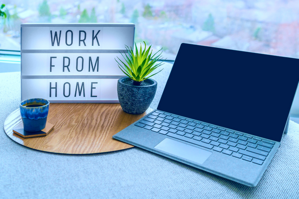 Laptop and Work From Home sign on a computer desk