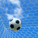 A football flying through the air into the net